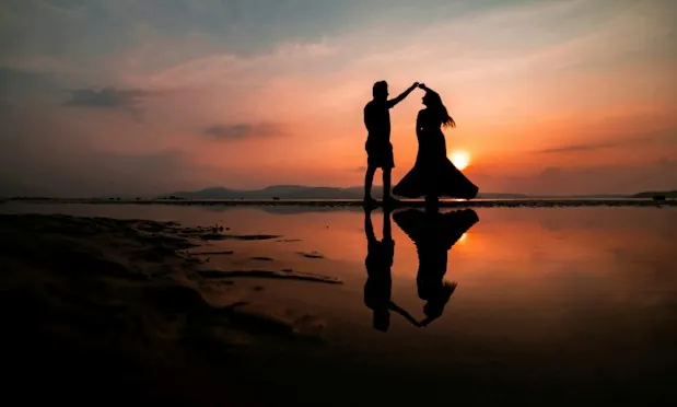 A couple dancing at sunset by the water