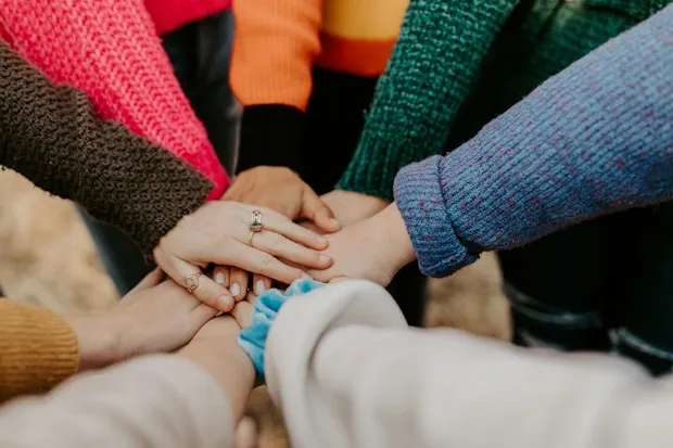 A team stacking their hands together